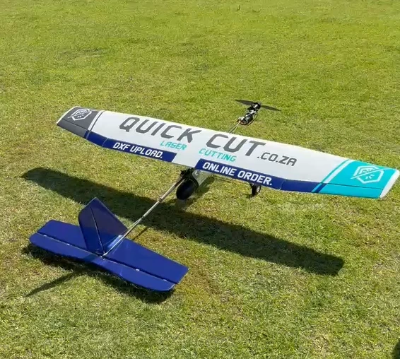 The finished aircraft on the grass, with QuickCut branding on the wing