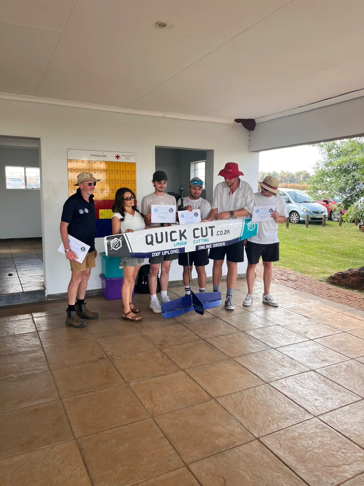 The University of Pretoria team holding their certificates behind their QuickCut-branded model aircraft