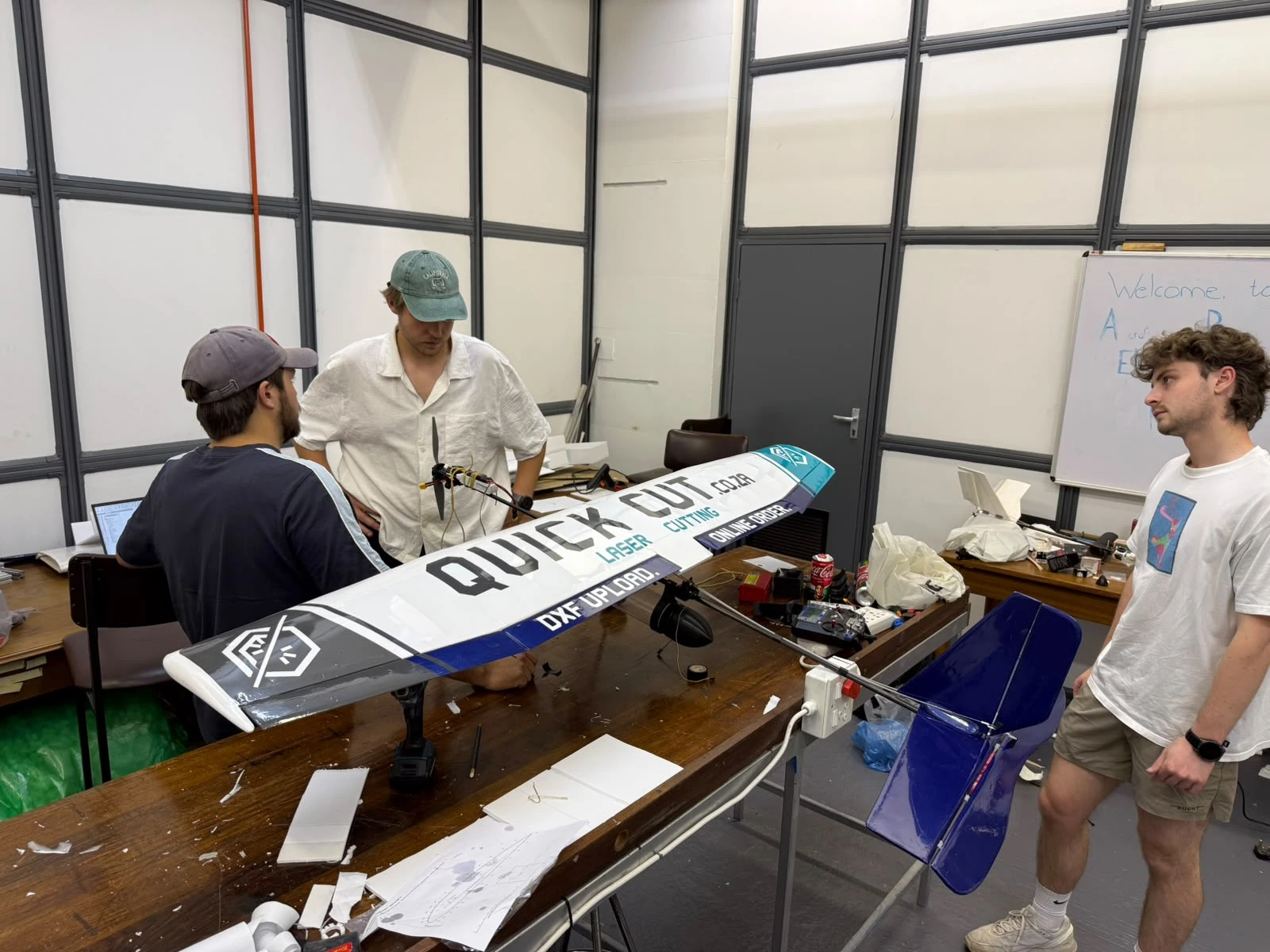 Team members working on the finished aircraft in the workshop